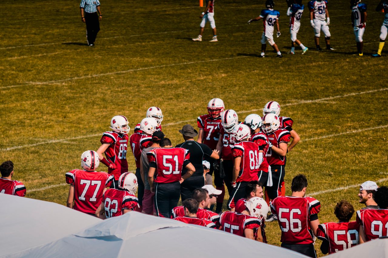 Mastering the First Impression: Your intriguing post title goes here American football team huddling on field for strategy meeting during a game.